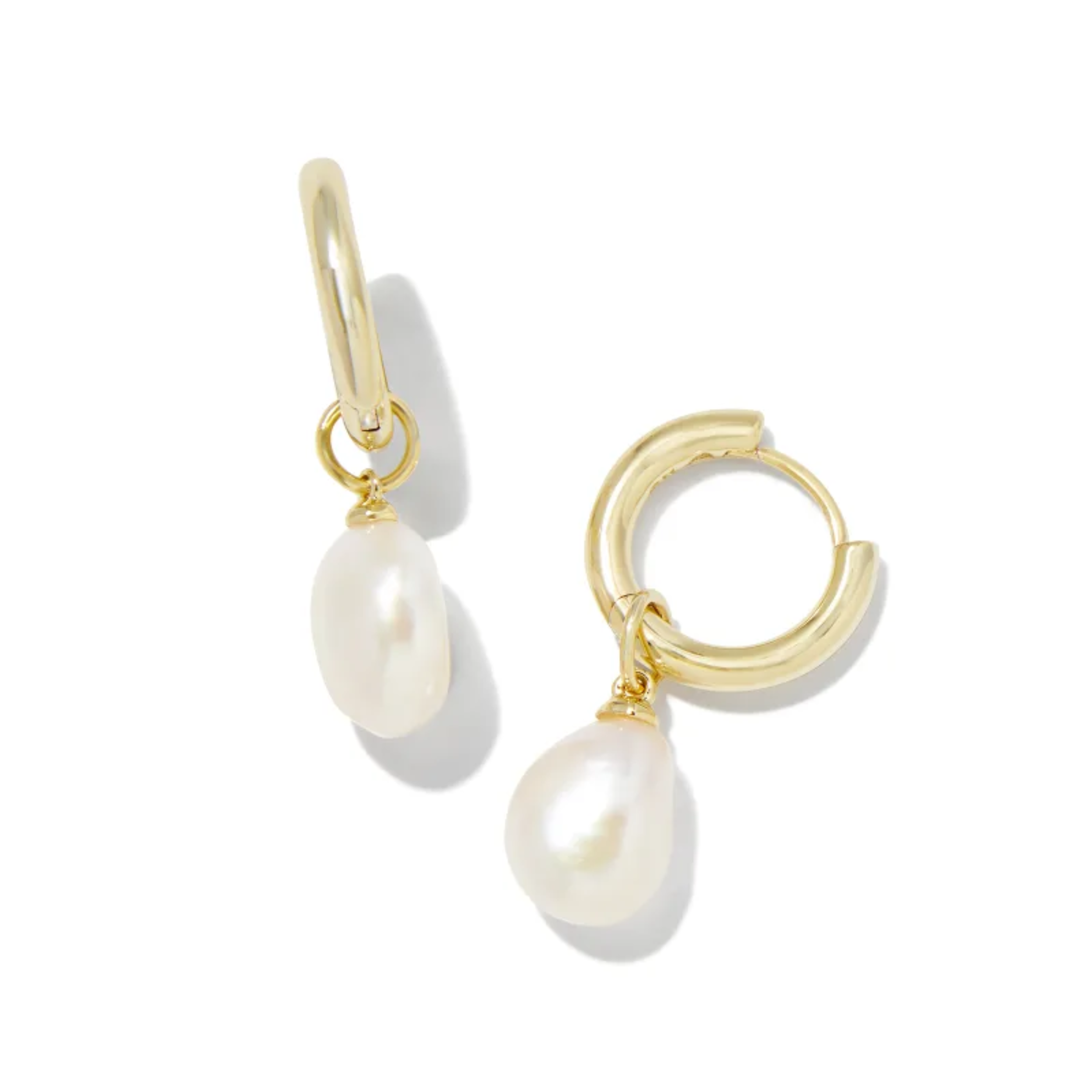 These Willa Gold Huggie Earrings in White Pearl by Kendra Scott are pictured on a white background.