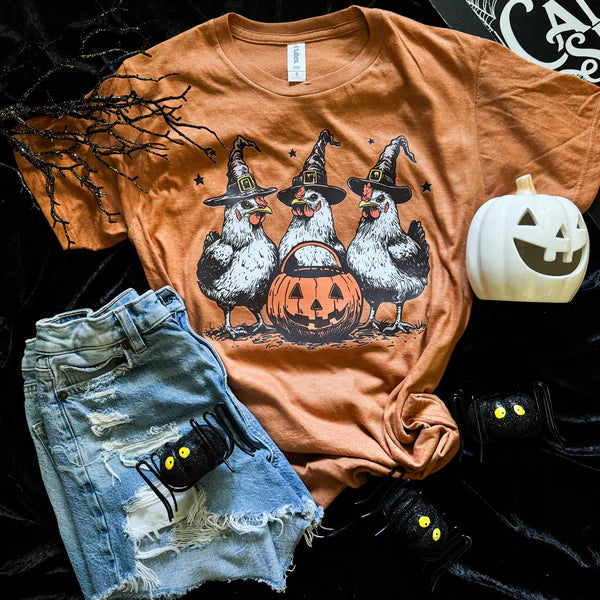 Orange t-shirt with Halloween chicken design, denim shorts, and pumpkin on a dark background