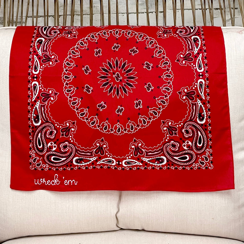 Red bandana with white patterns on a white pillow in a wicker chair