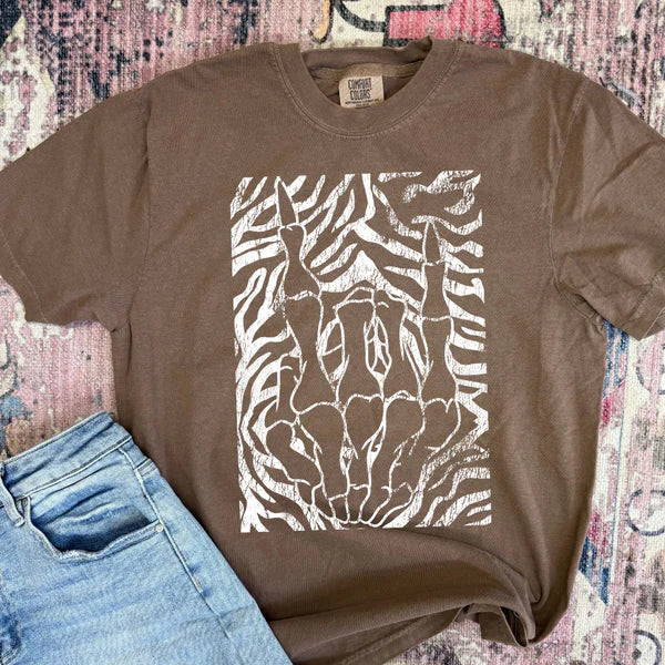 Brown t-shirt with zebra pattern design on a textured surface