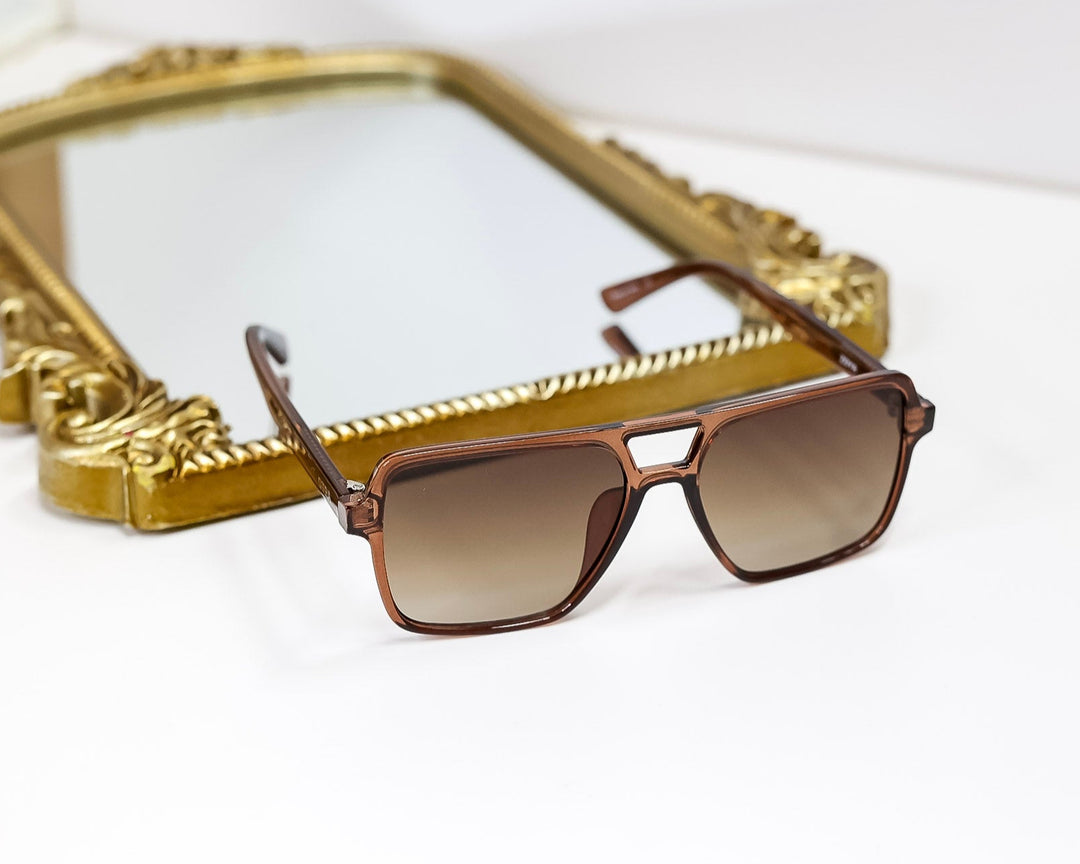 Sunglasses with a gold frame on a white surface