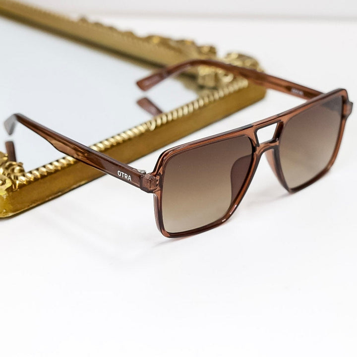 Brown sunglasses with gold frame on a white background