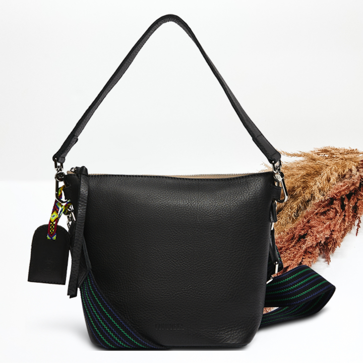 Pictured on a white background is a black wedge purse. 