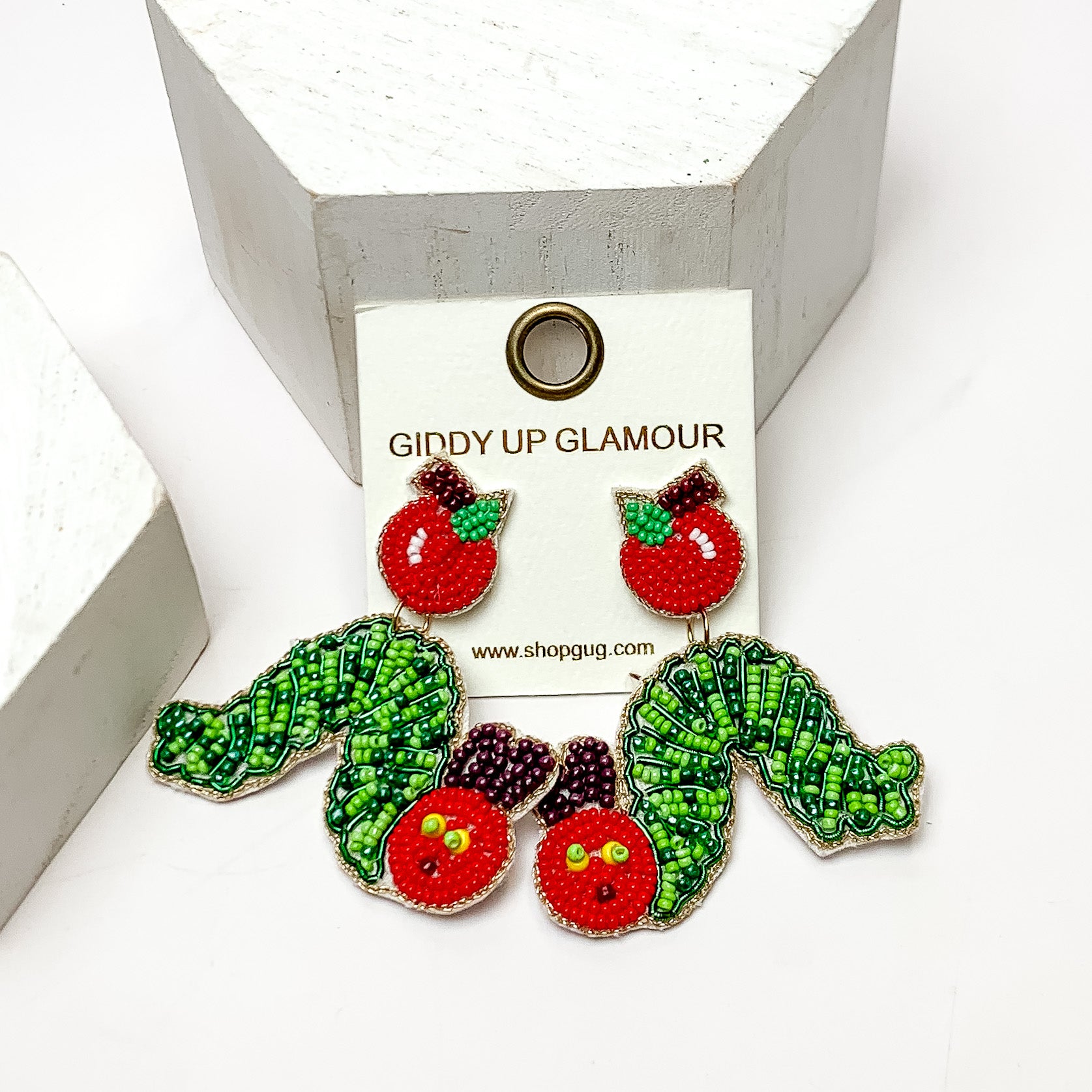 Caterpillar Beaded Earrings With Apple Posts in Green and Red. These earrings are on a white background and have white posts around them.