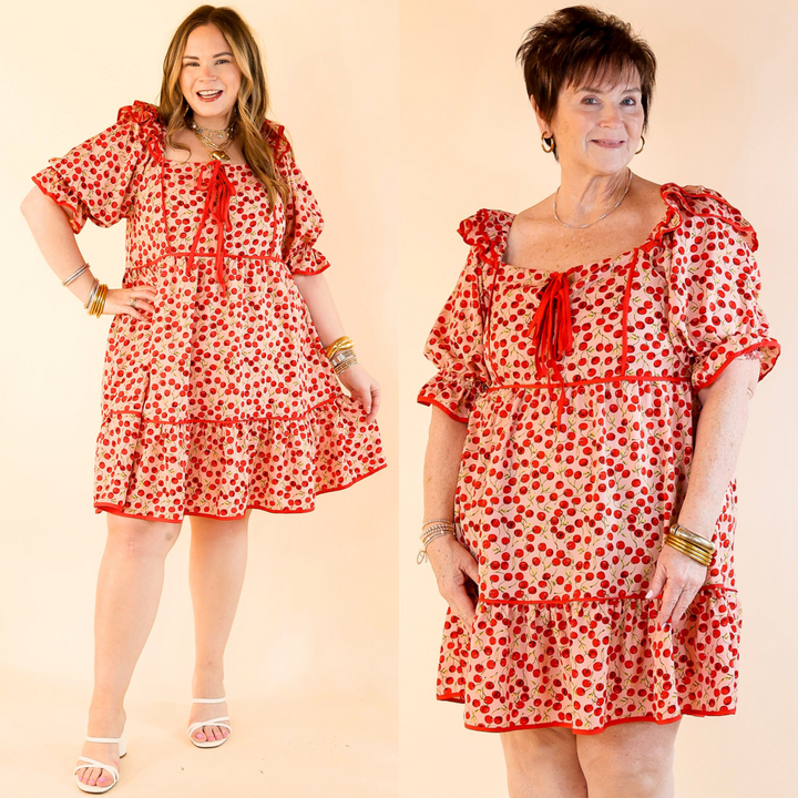 This light pink mini dress features a cherry print, keyhole neckline with two delicate bow ties, ruffled shoulders, and puff sleeves. Sizes small to large. 