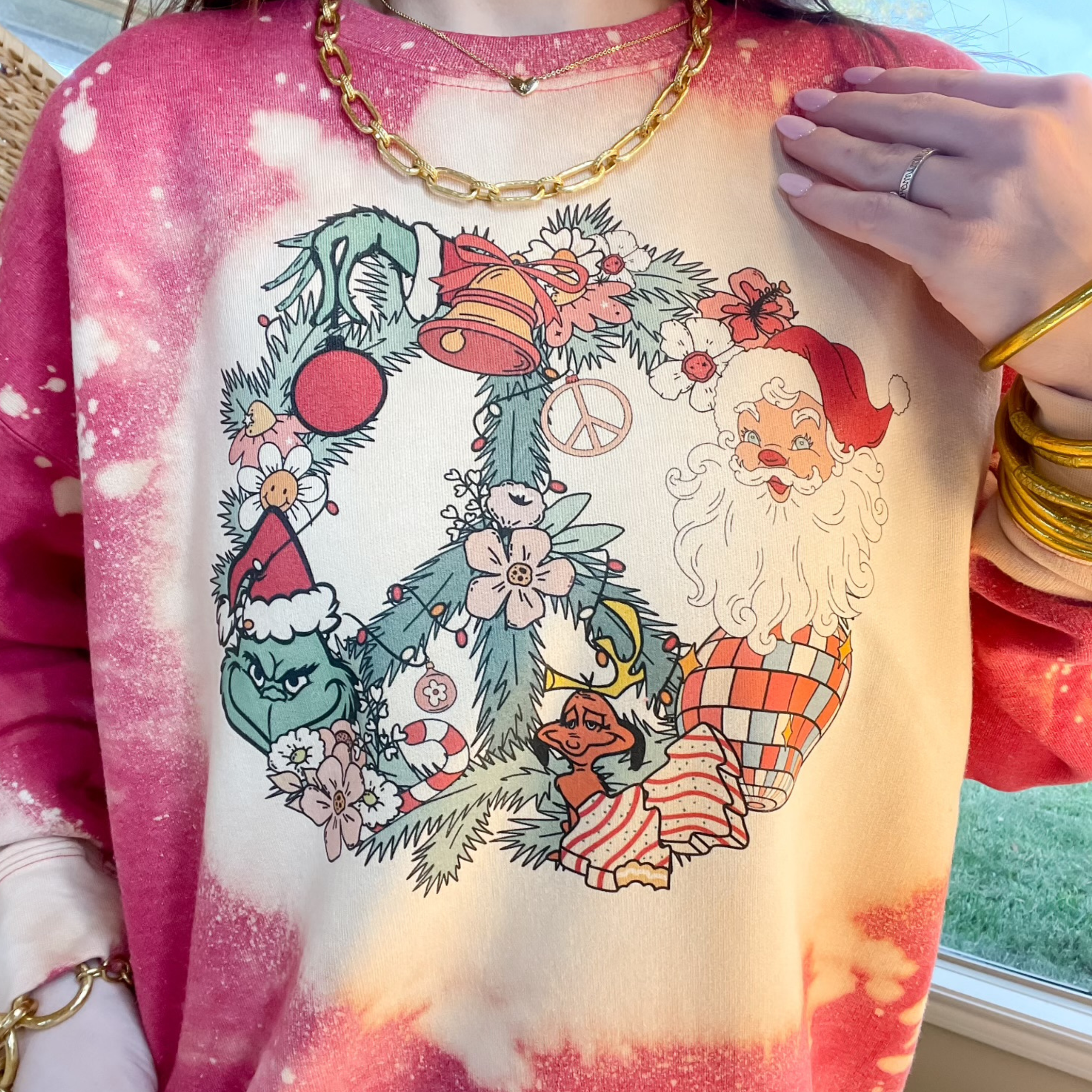 Photo features a red bleached sweatshirt with a christmas peace wreath on the front. 