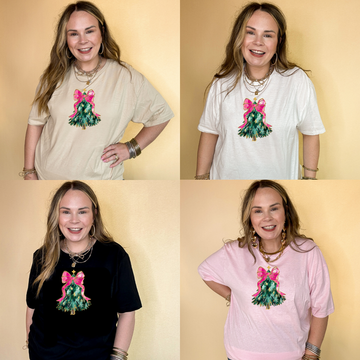 Four women wearing tees in tan, white, black and pink printed with a Christmas tree with a pink bow.