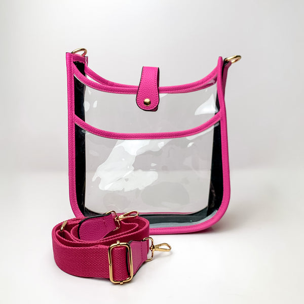 Clear crossbody purse in fuchsia with a fuchsia purse strap pictured in front of the purse. This purse is pictured on a white background. 