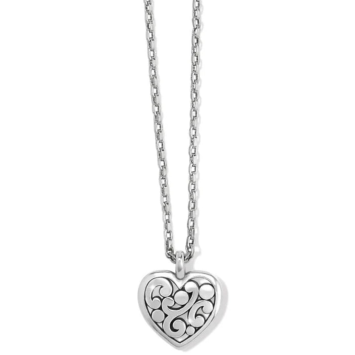 A silver necklace with heart pendant on a white background