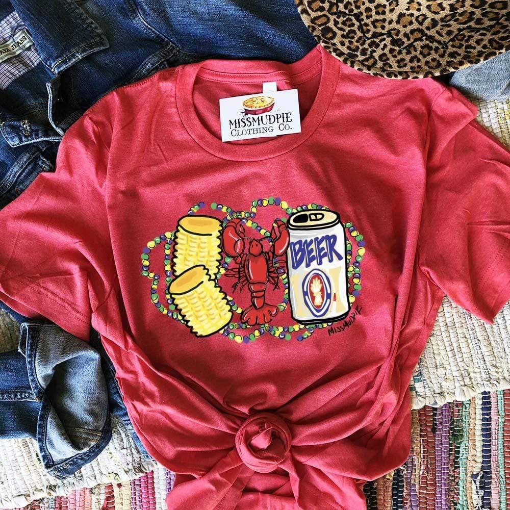A red short sleeve tee featuring a graphic of a red crawfish with two corn on the cobs and a beer. Behind the crawfish are purple, green, and yellow mardi gras beads
