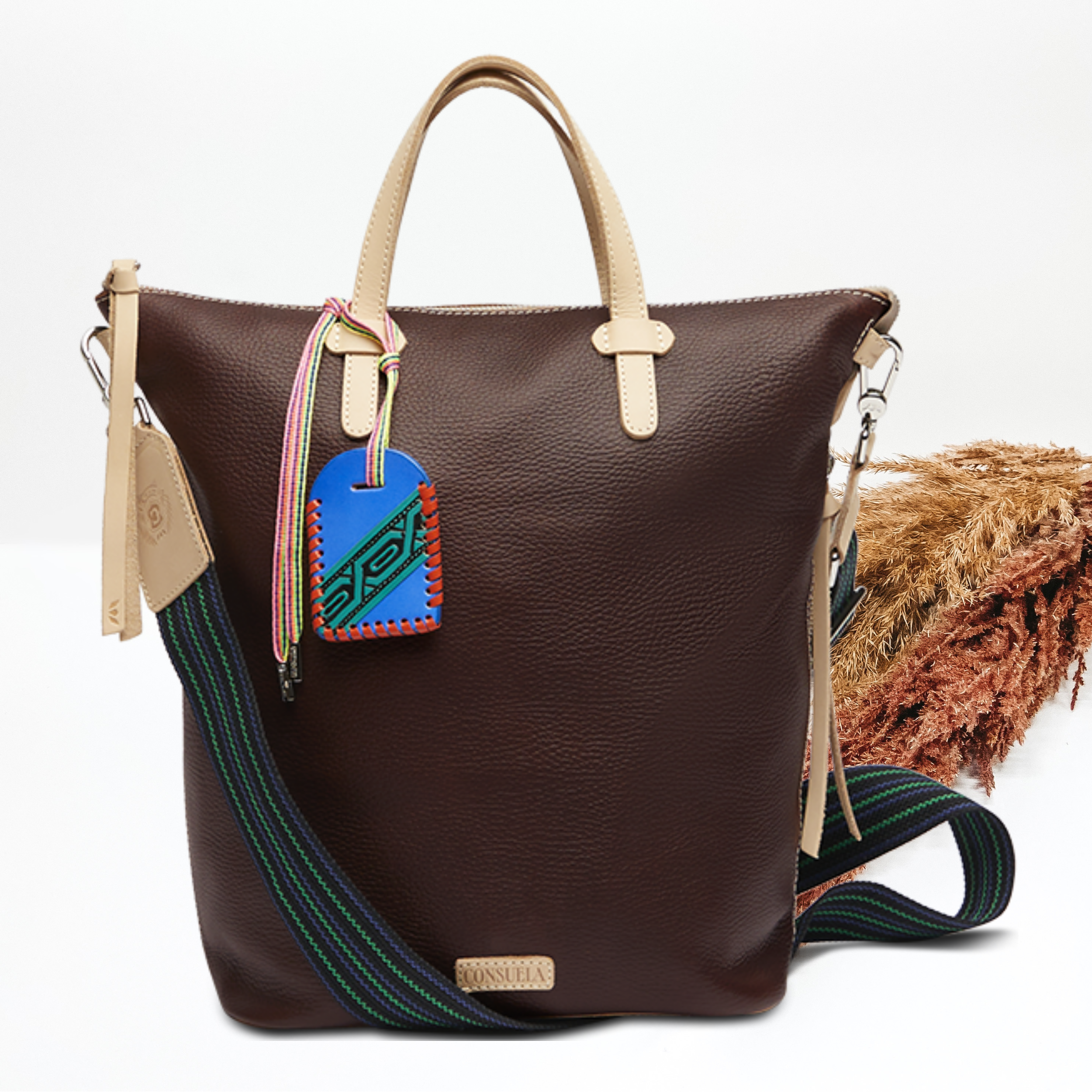 Pictured on a white background is a dark brown leather sling bag. 