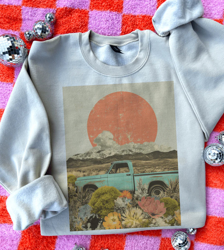 Gray sweatshirt with a graphic of a truck in a desert scene on a colorful checkered background.
