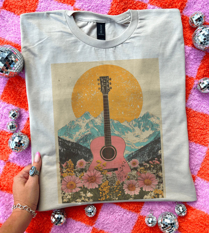 Smoke and Embers graphic tee with pink guitar & mountain sunset design – cream shirt