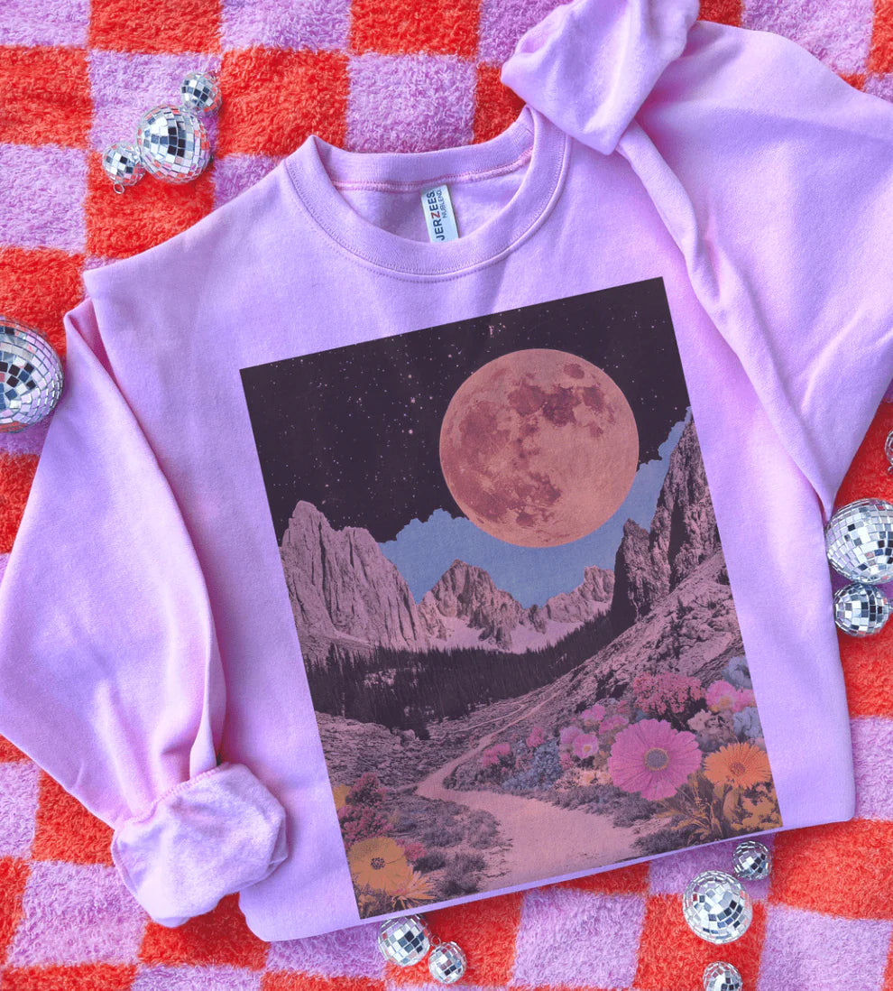 Pink sweatshirt with a mountain and moon design on a red and pink checkered background