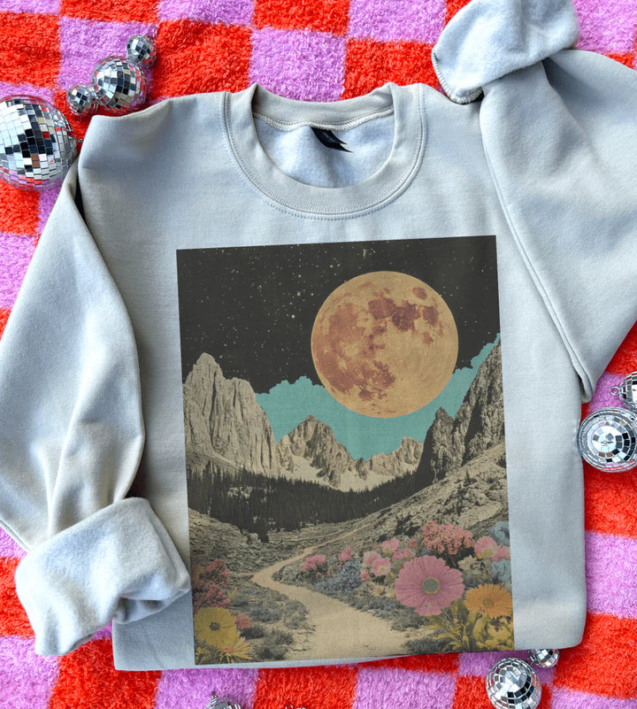 Cream sweatshirt with a mountain and moon design on a checkered background
