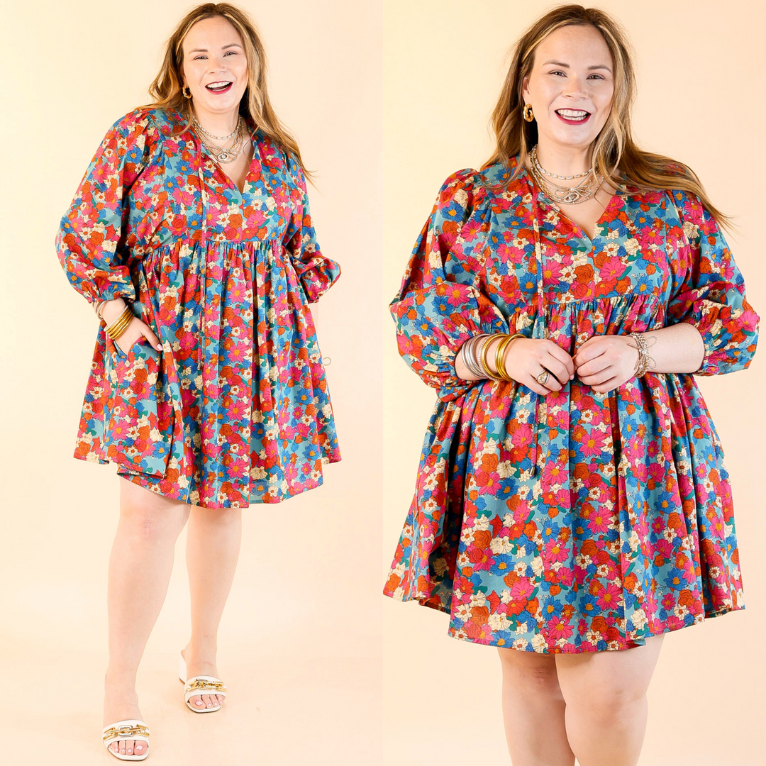 This dress includes half sleeves, a babydoll style body, a keyhole-tie neckline, and a cute floral print in a mix of turquoise, orange, ivory, and pink. Sizes small to large.
