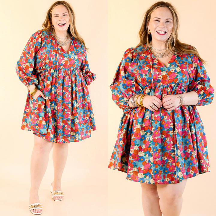 This dress includes half sleeves, a babydoll style body, a keyhole-tie neckline, and a cute floral print in a mix of turquoise, orange, ivory, and pink. Sizes small to large.