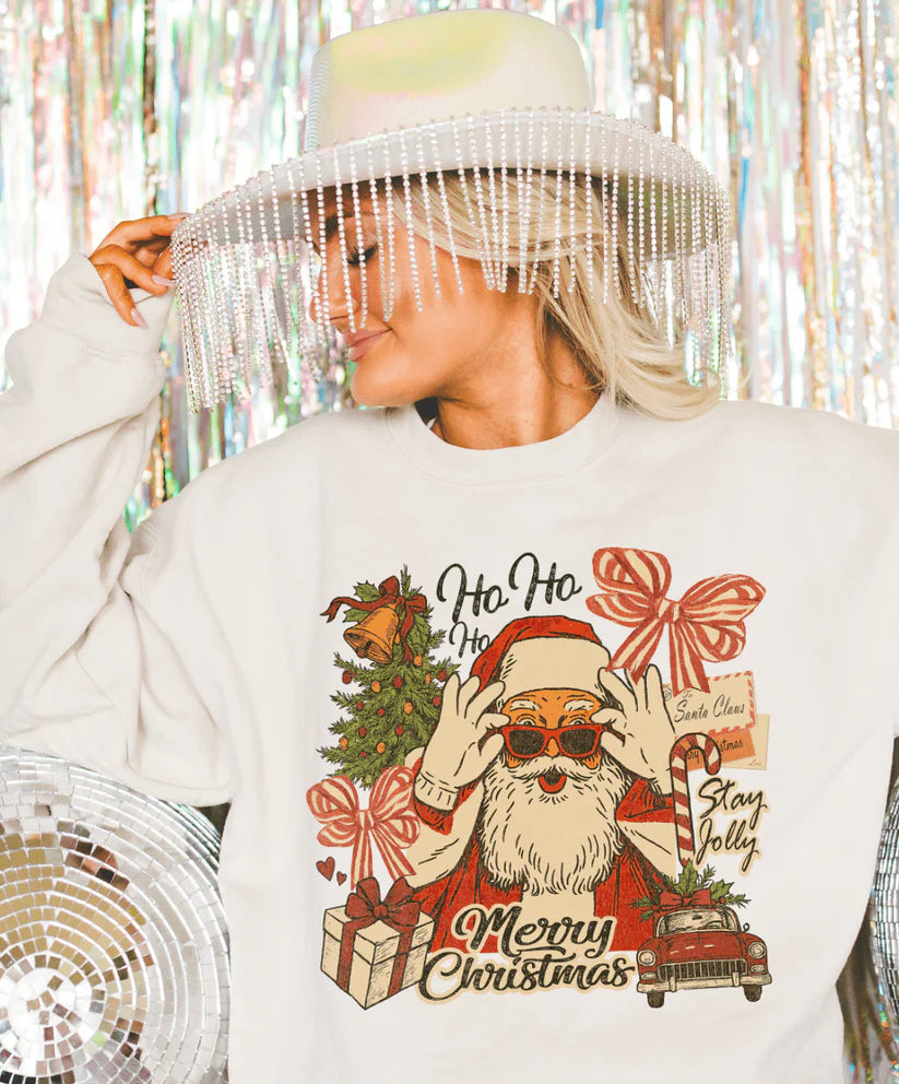 Cream tee with retro Santa collage design featuring gifts, bows, and a Stay Jolly message – vintage Christmas graphic from Giddy Up Glamour.