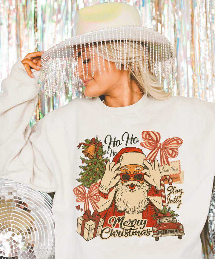 Cream tee with retro Santa collage design featuring gifts, bows, and a Stay Jolly message – vintage Christmas graphic from Giddy Up Glamour.