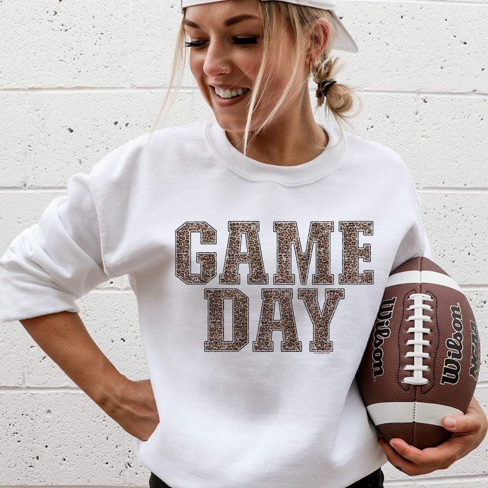 Model is wearing a white sweatshirt featuring a leopard print graphic that says "Game day"