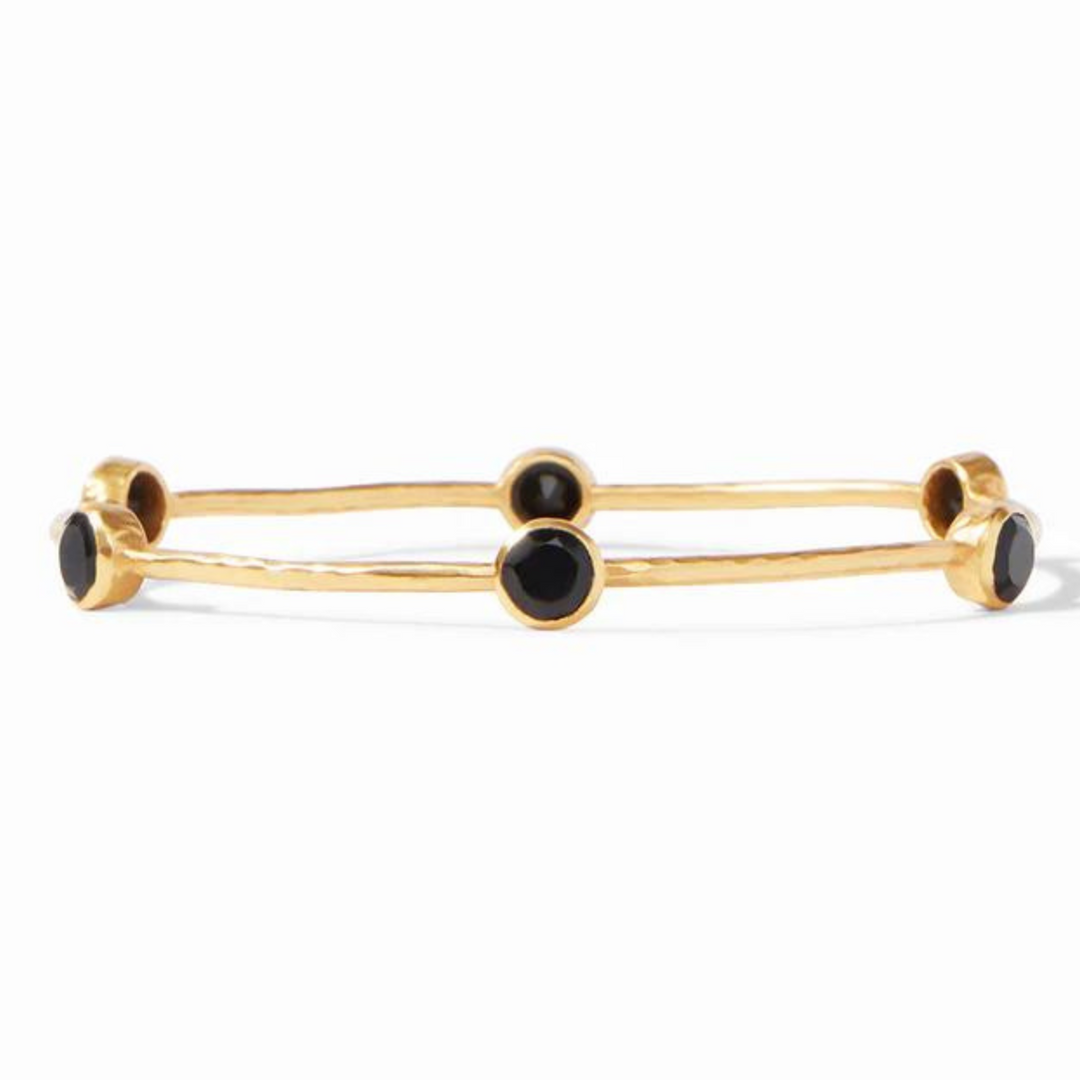 Gold bangle with black crystals pictured on a white background. 
