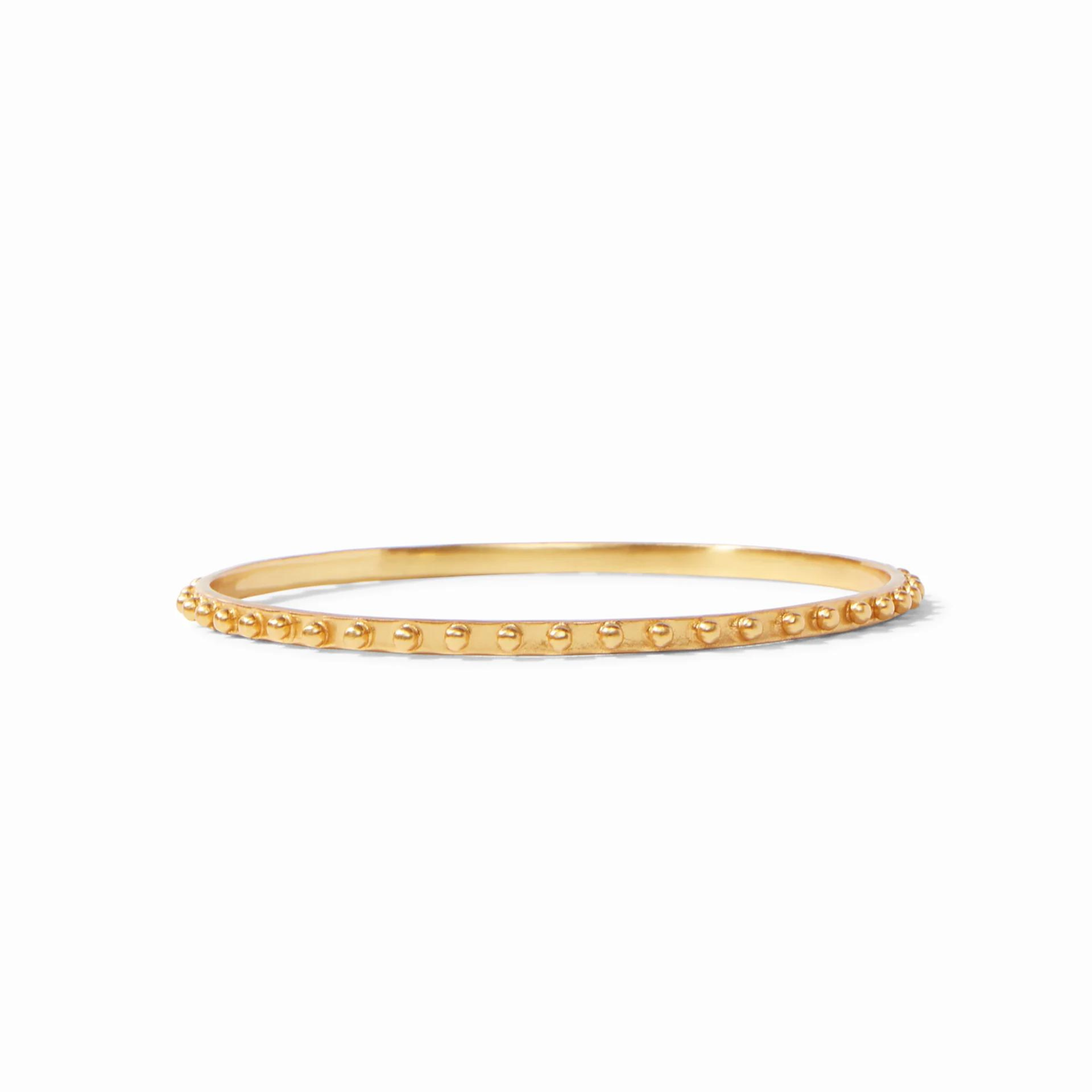 Gold bangle pictured on a white background. 