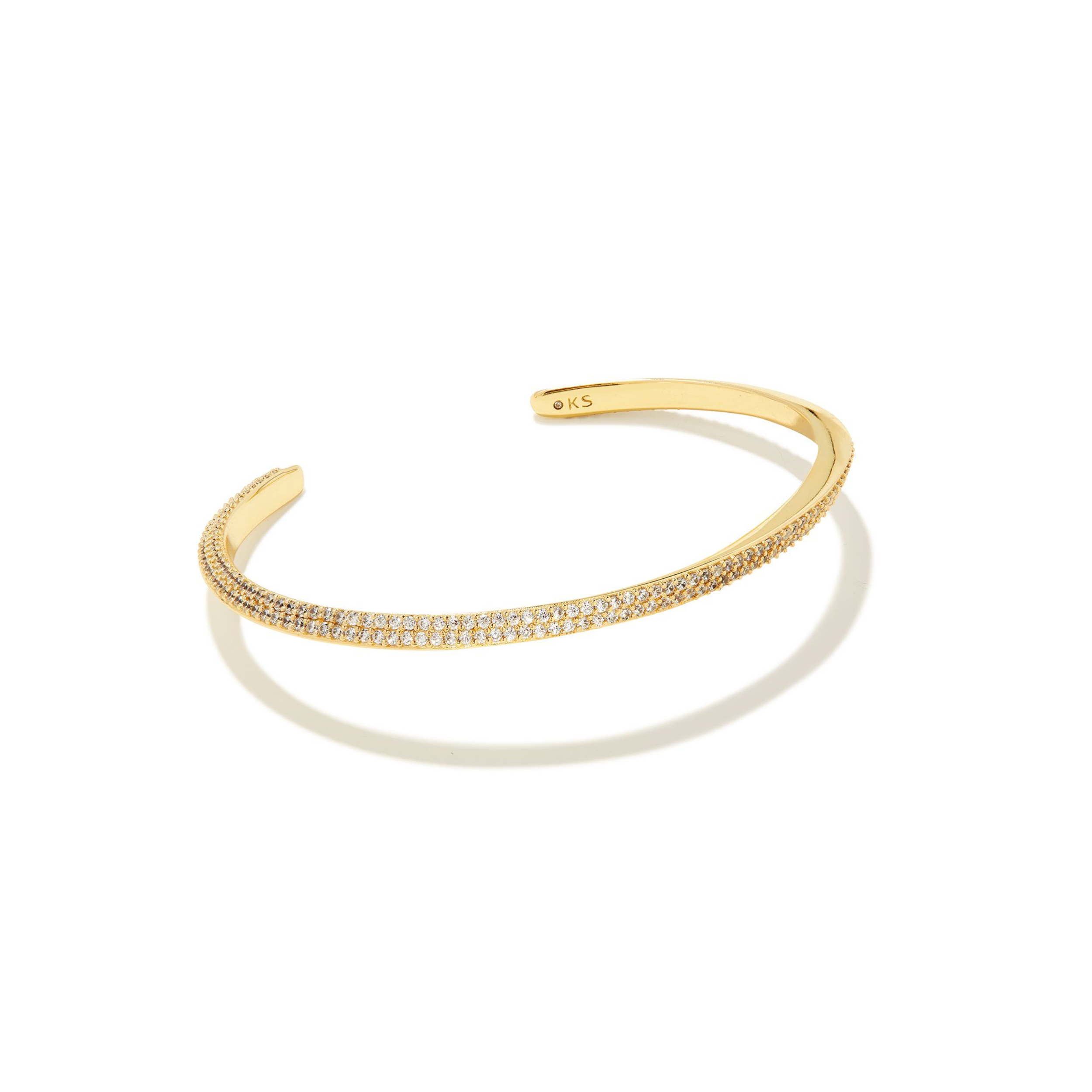Gold cuff bracelet with cz crystals pictured on a white background. 