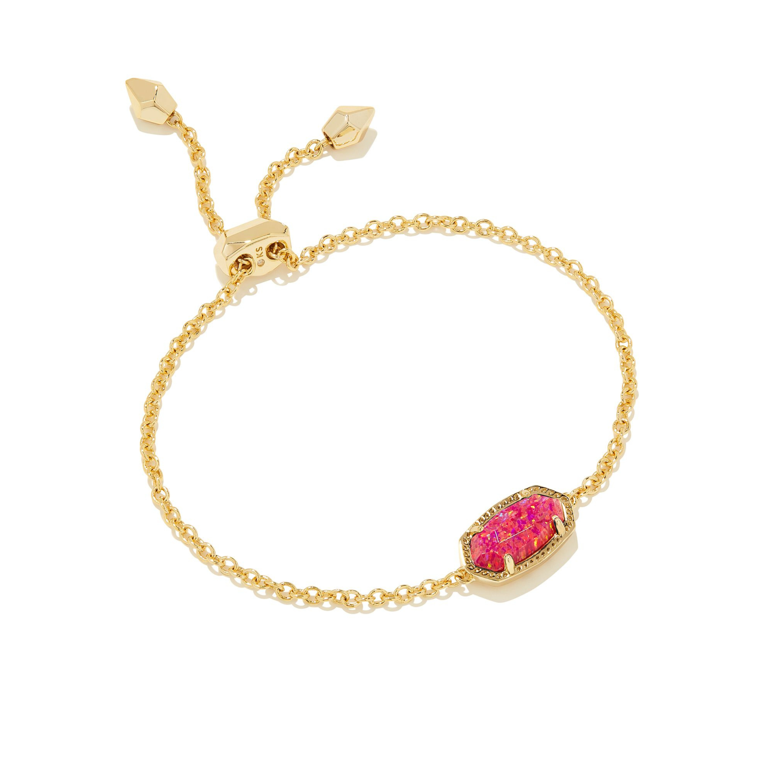 Gold chain bracelet with oval red opal pendant pictured on a white background. 