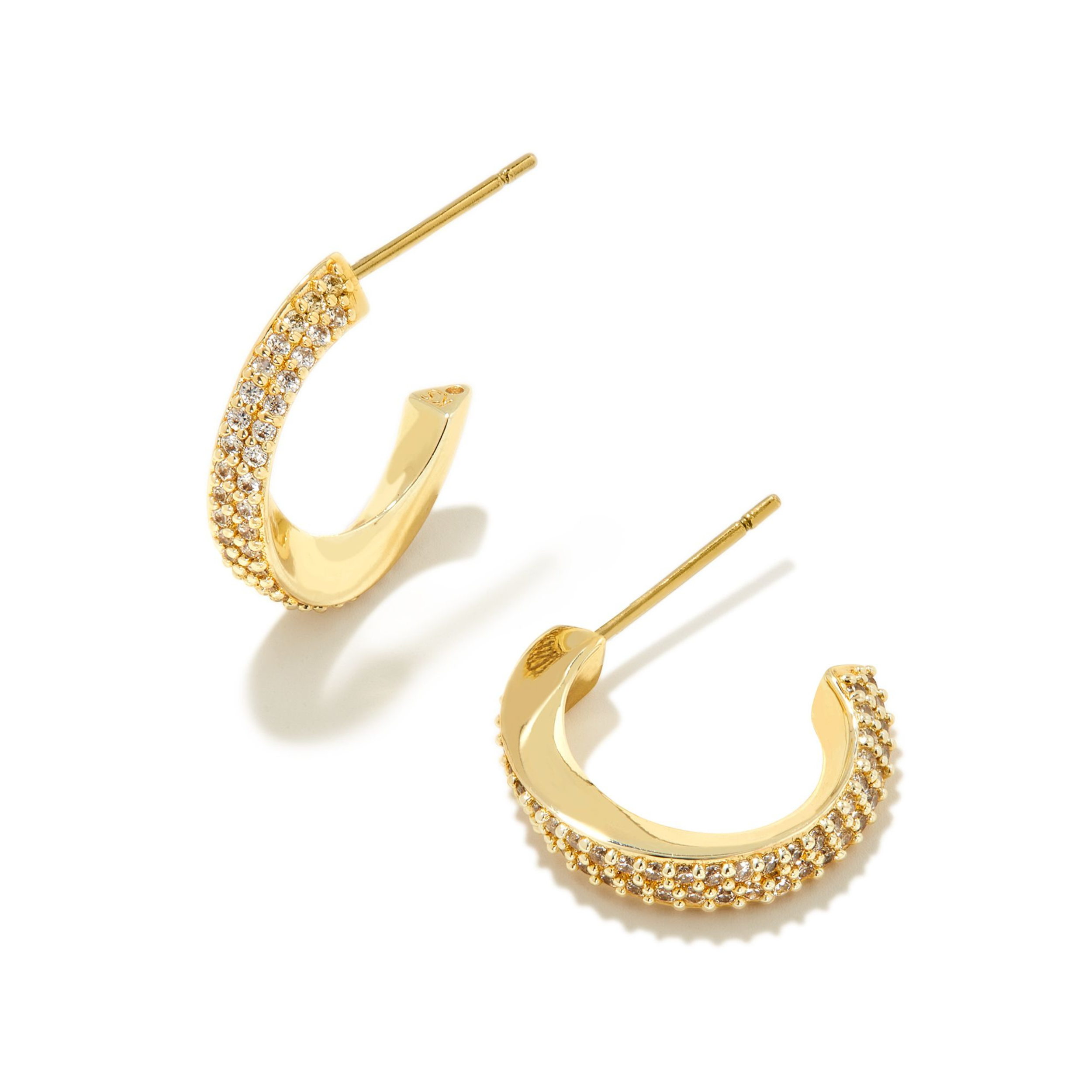 Gold hoop huggie twist earrings with cz crystals pictured on a white background. 