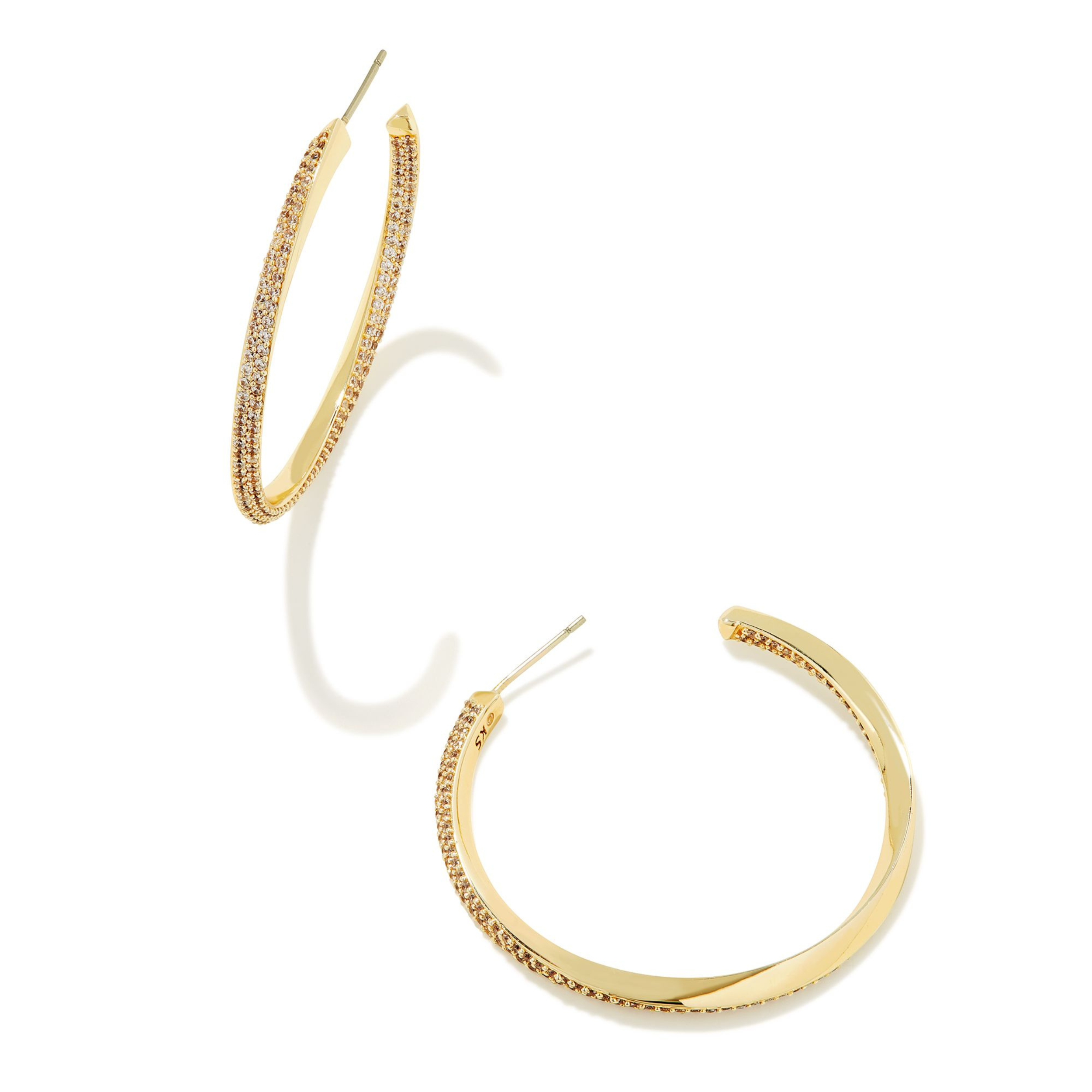 Gold hoop huggie twist earrings with cz crystals pictured on a white background. 