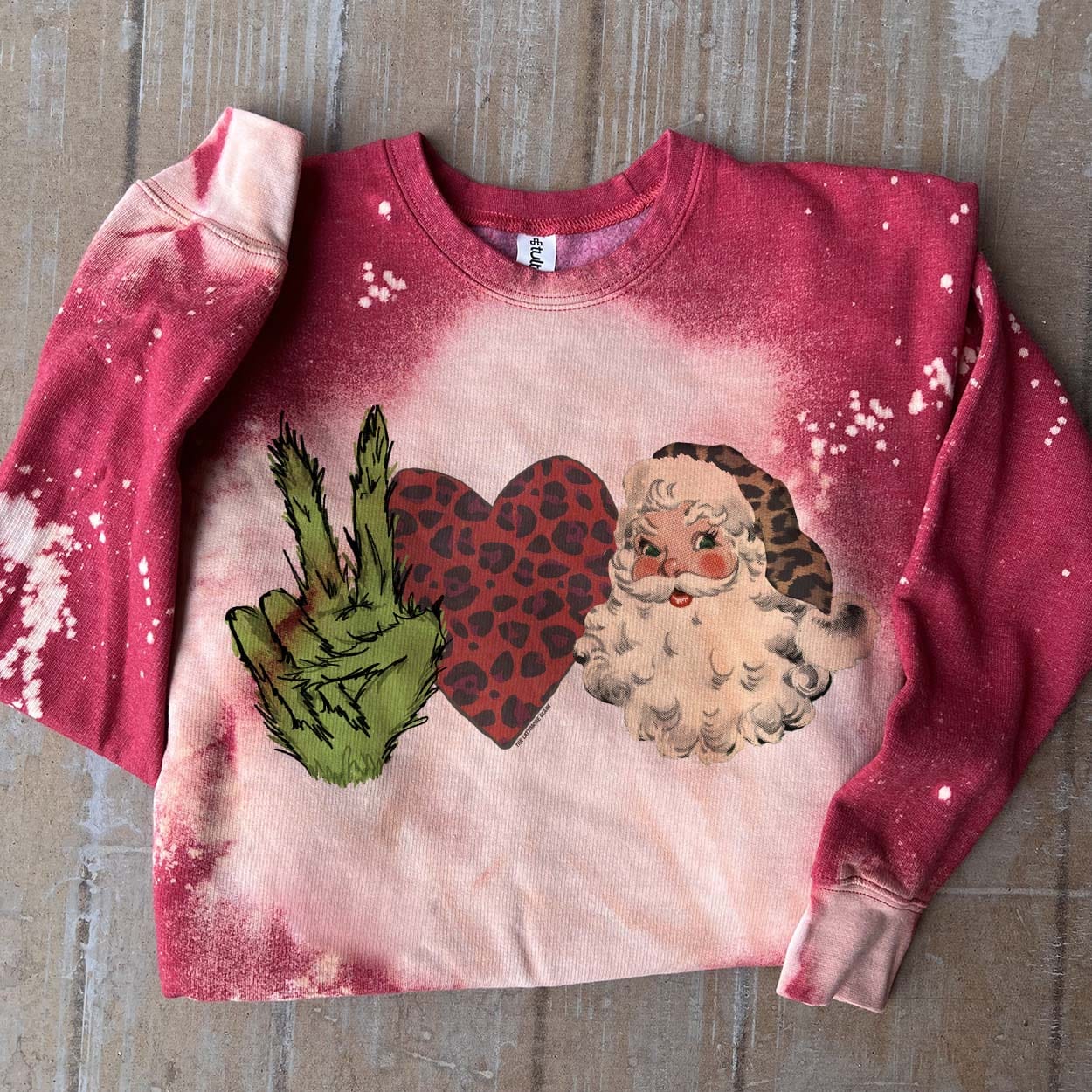 Online Exclusive | Grinch Love Santa Long Sleeve Bleached Splatter Graphic Sweatshirt in Red - Giddy Up Glamour Boutique