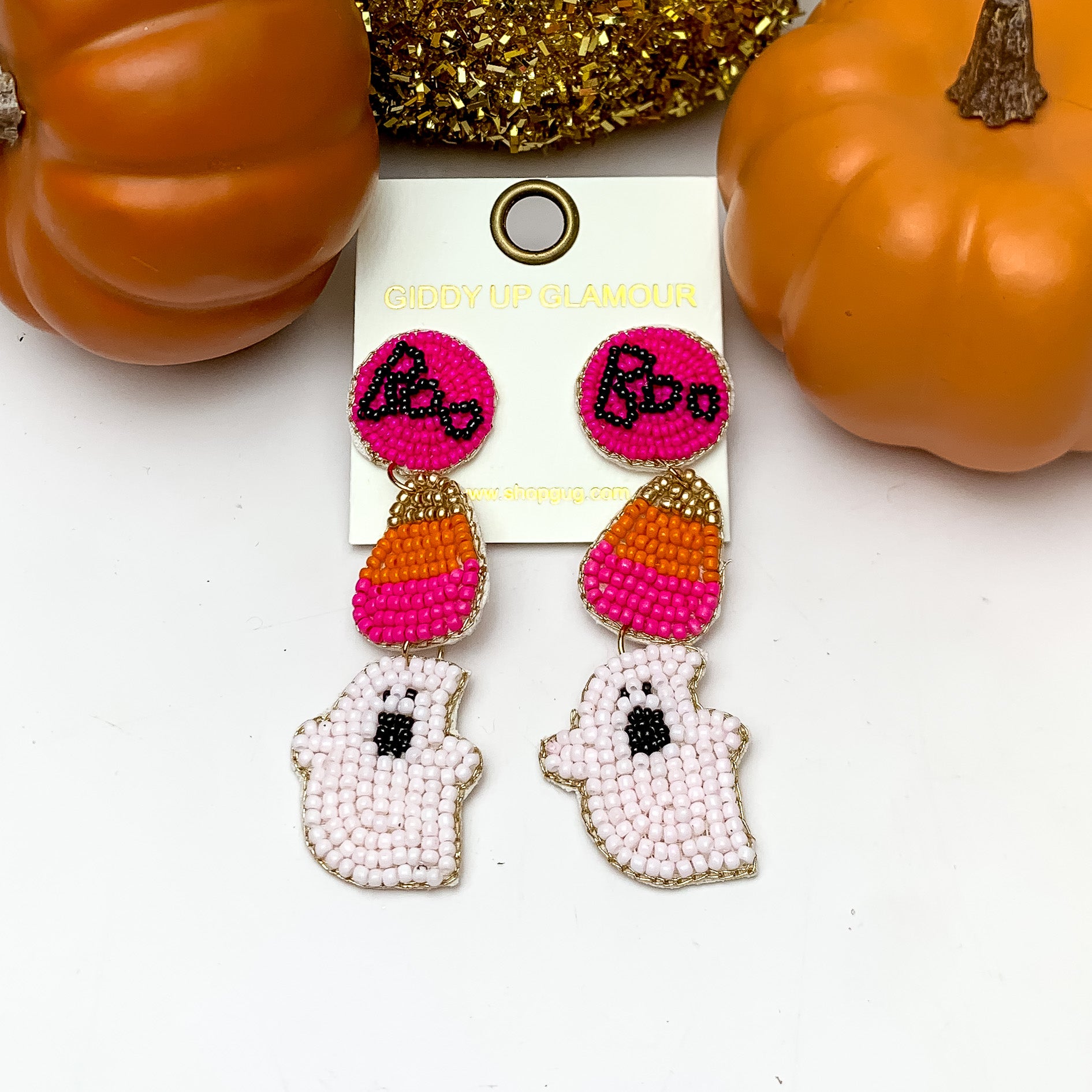 Three Tier Halloween Themed Beaded Earrings in Pink and Orange. These earrings are pictured on a white background with pumpkins behind the earrings.