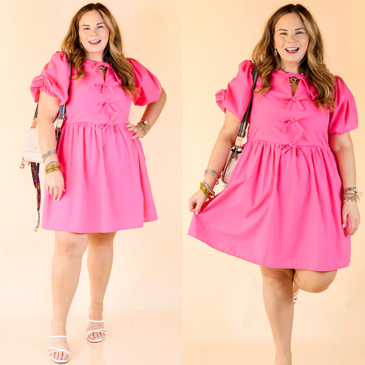 Short puff sleeve dress with bows down the front. Dress is a solid hot pink color.