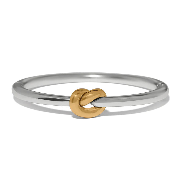 Silver ring with a gold knot design on a white background