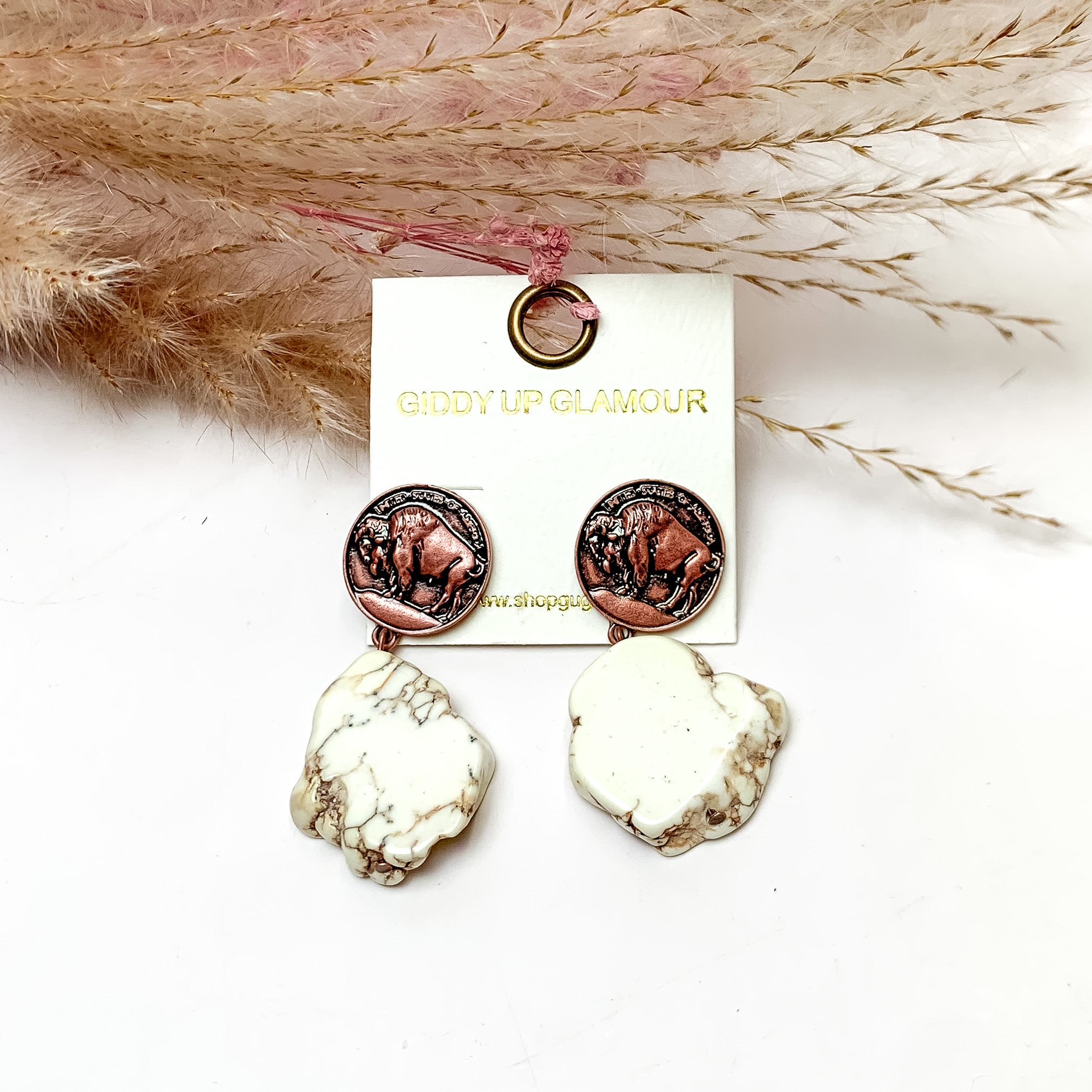 Ivory Stone Earrings With Copper Tone Coin Posts. These earrings are pictured on a white background with flowers behind for decoration.