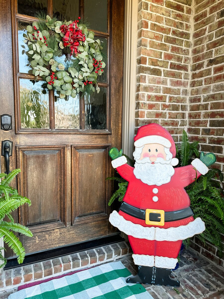 The Round Top Collection Joyful Santa Yard Stake styled on a brick front porch