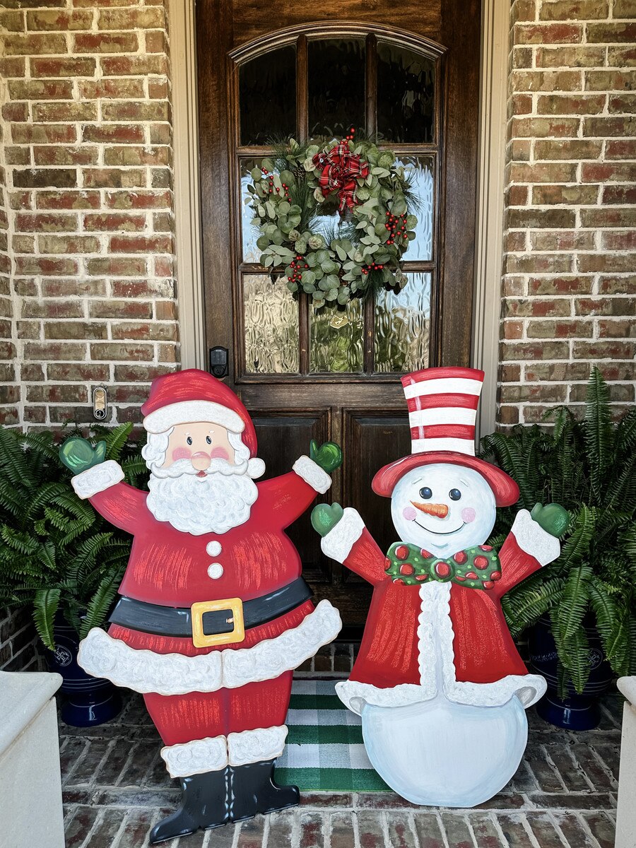 The Round Top Collection Joyful Santa Yard Stake displayed on a front porch