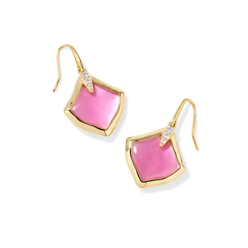 A solid white background with gold drop earring with a pink center stone.