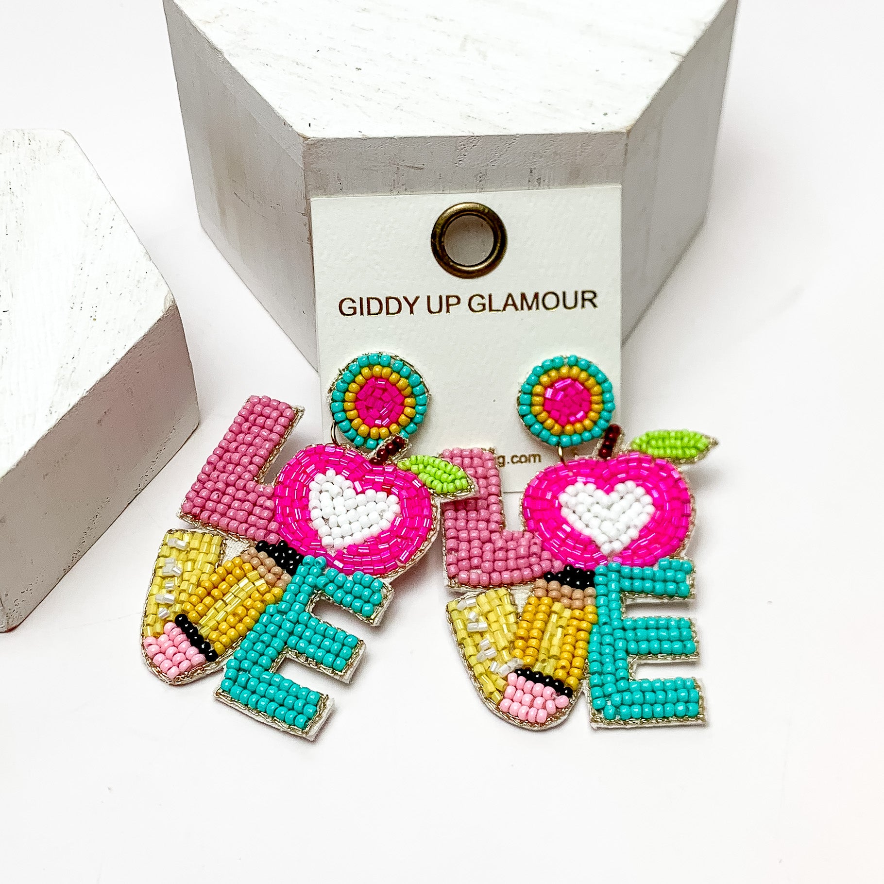 LOVE Beaded Earrings Teacher Themed in Multicolor. These earrings are on a white background and have white posts around them.