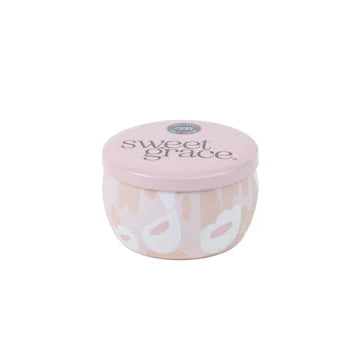 A small, travel-sized candle container with a floral pattern in shades of pink, gray, and white, labeled 'Sweet Grace'.
