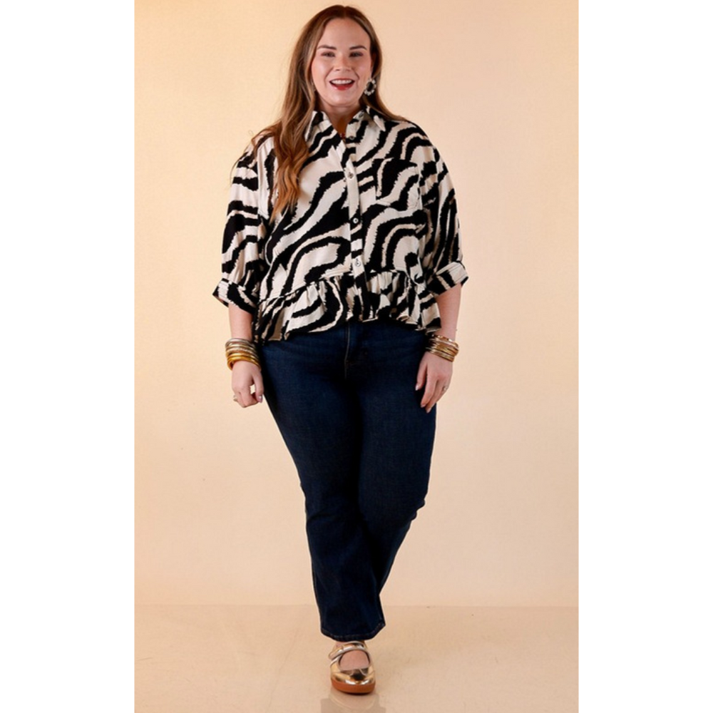 Full length image of a woman wearing the Making Waves Zebra Print Ruffle Hem Button Up Top in Black