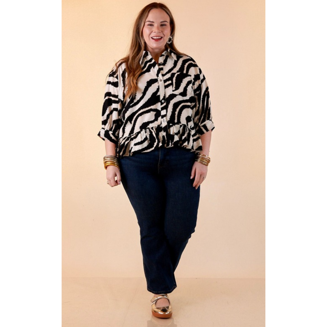 Full length image of a woman wearing the Making Waves Zebra Print Ruffle Hem Button Up Top in Black