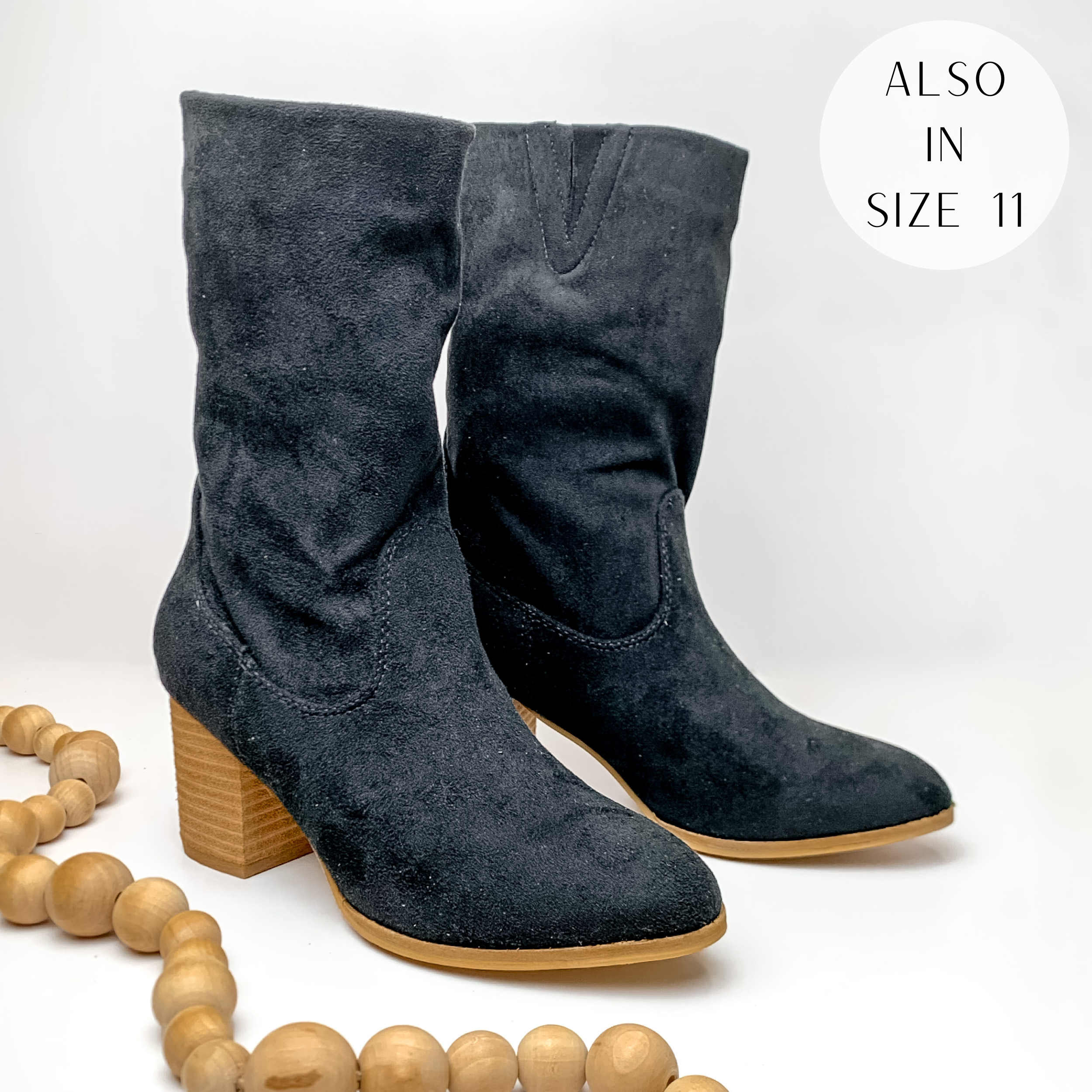 Suede calf booties with heel in black. Pictured on white background with light tan beads.