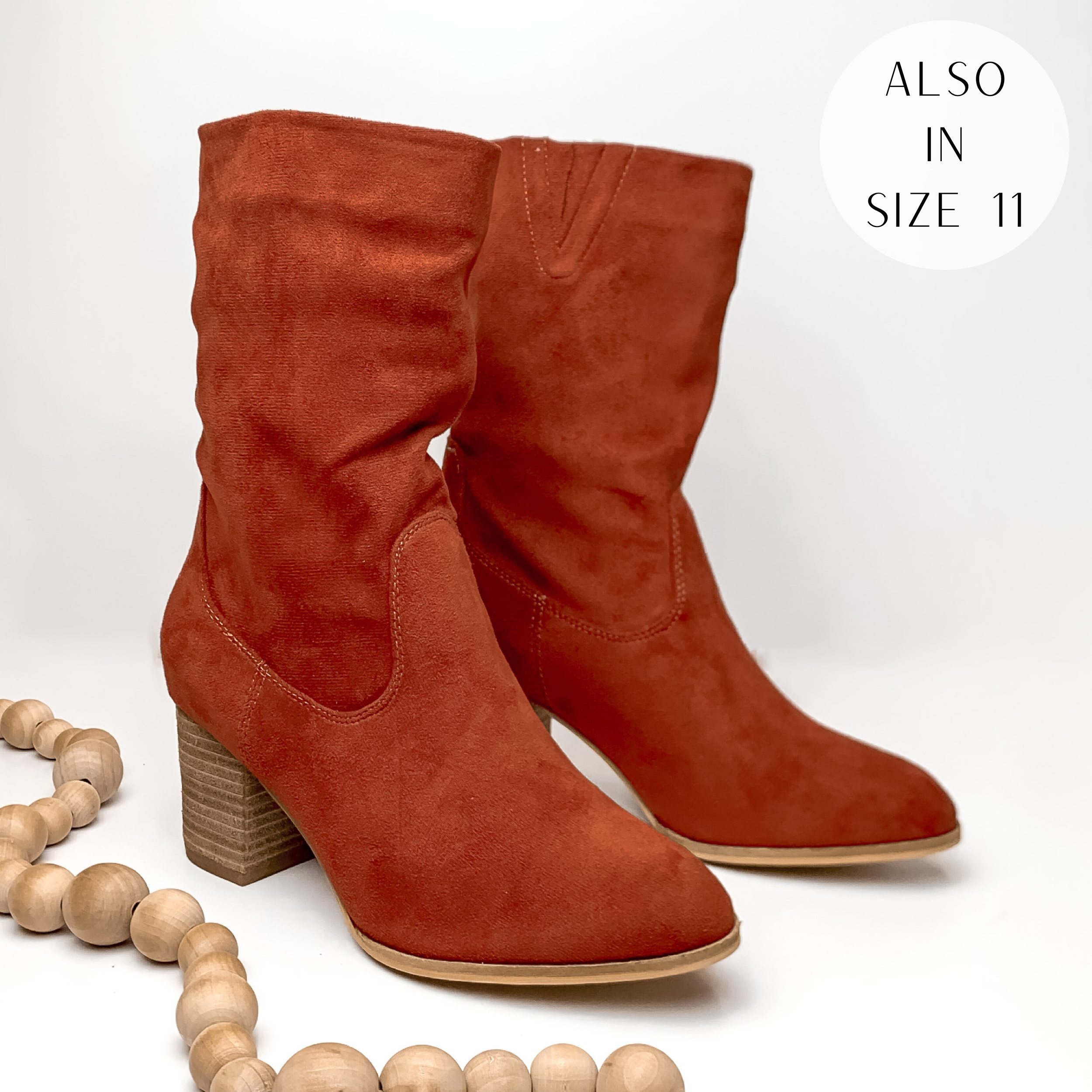 Suede calf booties with heel in rust red. Pictured on white background with light tan beads.