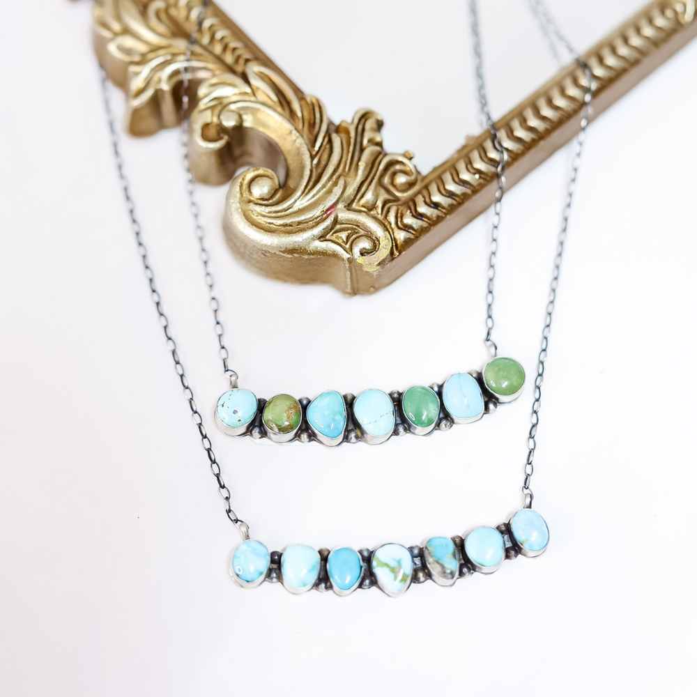 Necklace with turquoise and green gemstones on a white background