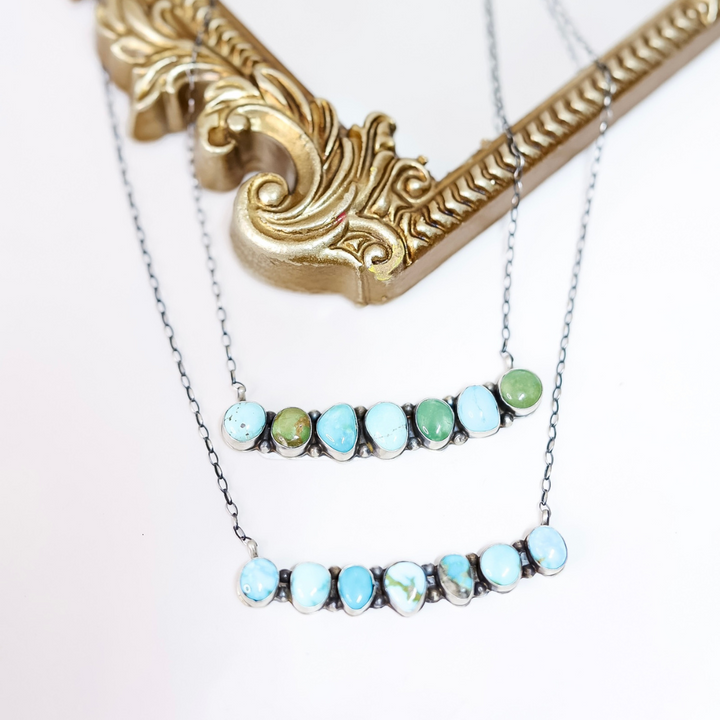 Necklace with turquoise and green gemstones on a white background