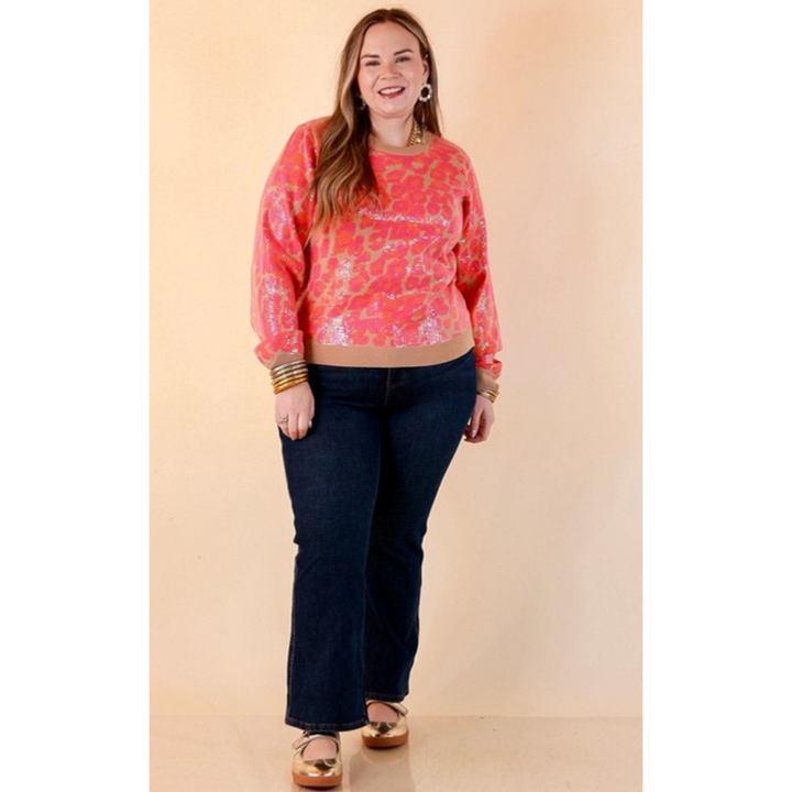 Full length image of a woman wearing the On the Prowl Sequin Leopard Long Sleeve Crew Neck Sweater in Hot Pink and Orange