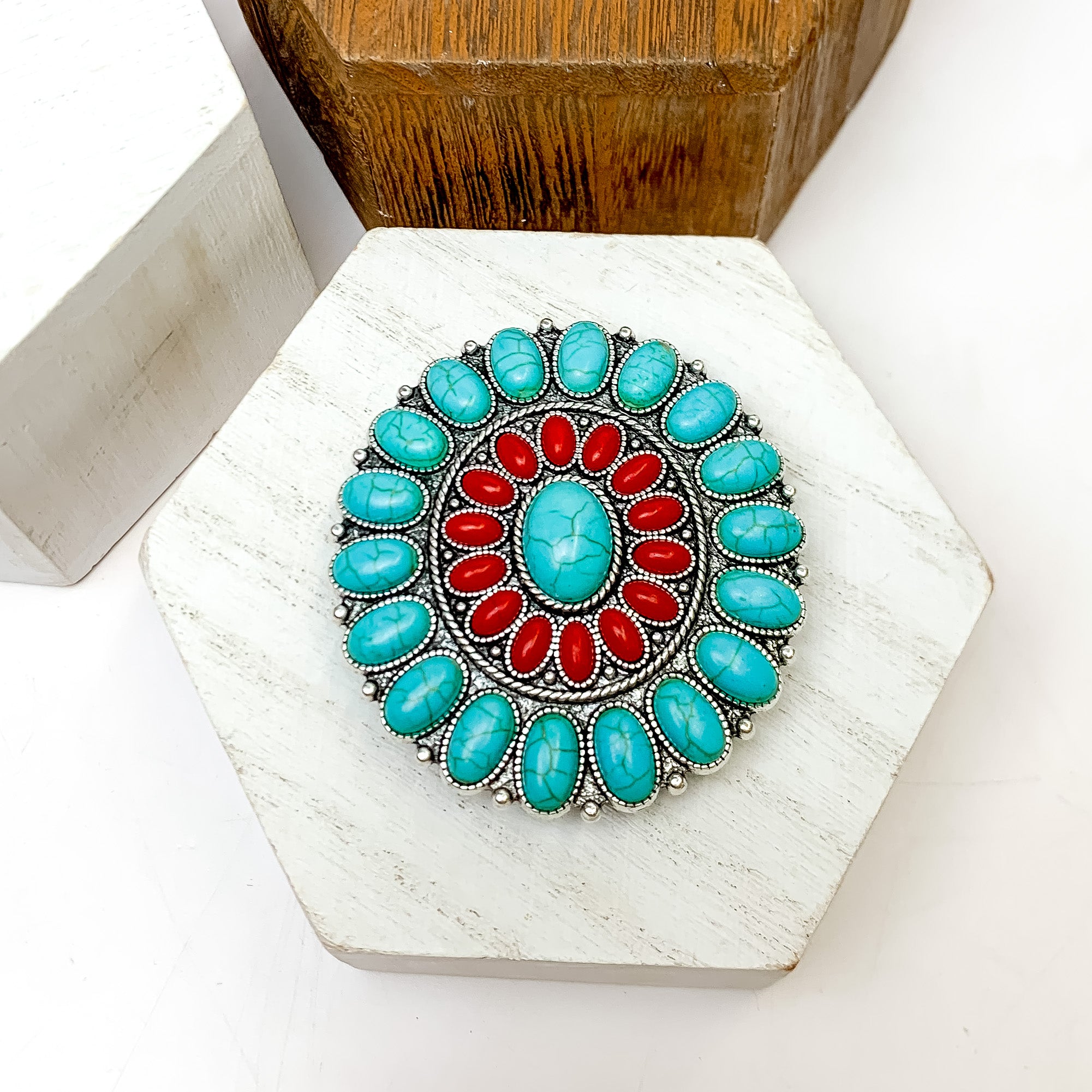 Silver Tone With Turquoise and Red Stone Circle Phone Grip. This phone grip is pictured on a white block with a white background behind it.