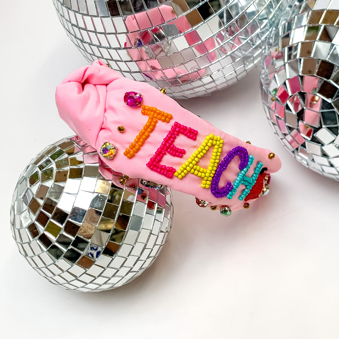 Beaded Multicolor Teacher Headband in Light Pink . This headband is pictured on a white background with disco balls next to the headband.