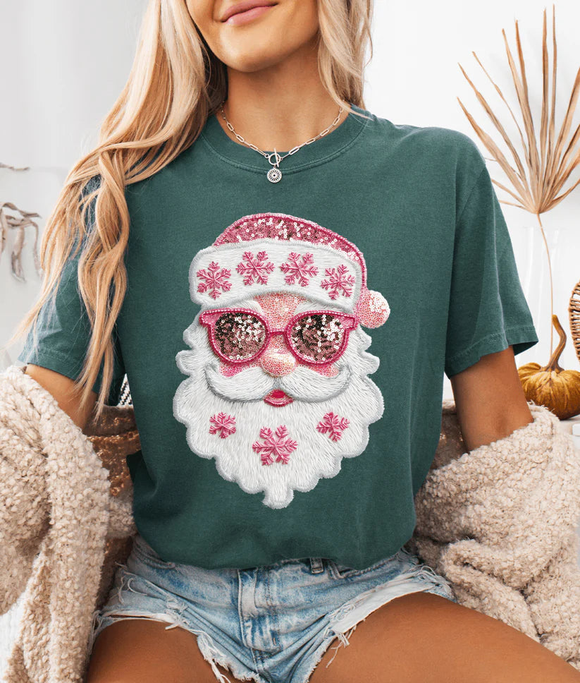 Woman wearing Pretty Pink Faux Sequin Santa Graphic Tee in Blue Spruce, featuring pink sequin-look Santa design with snowflakes.